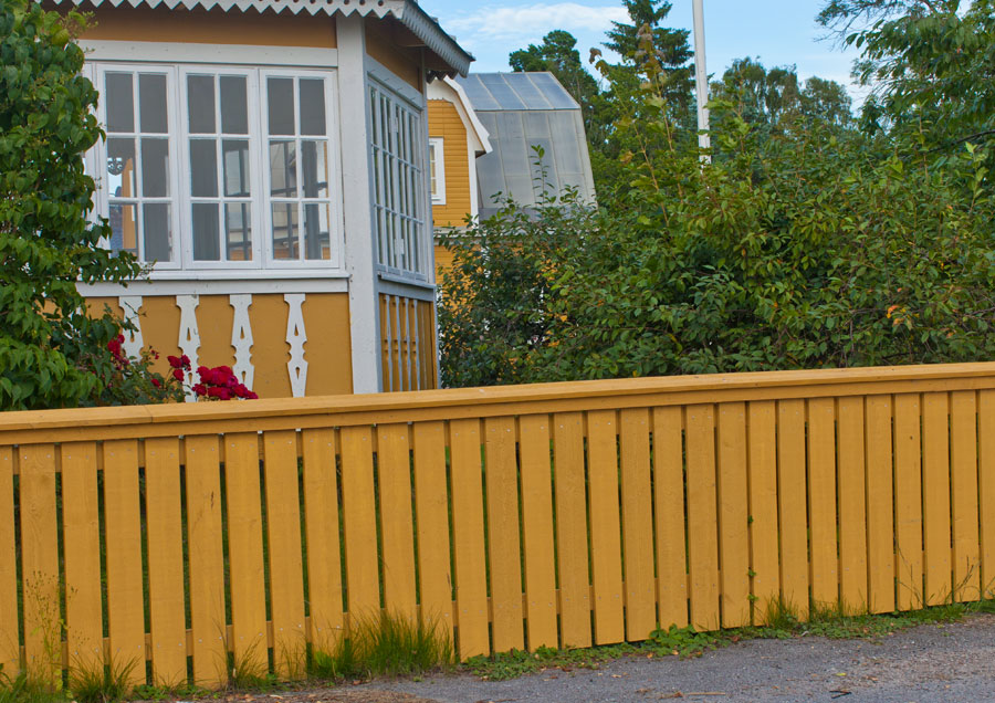 Villastaket målat med gul slamfärg.
