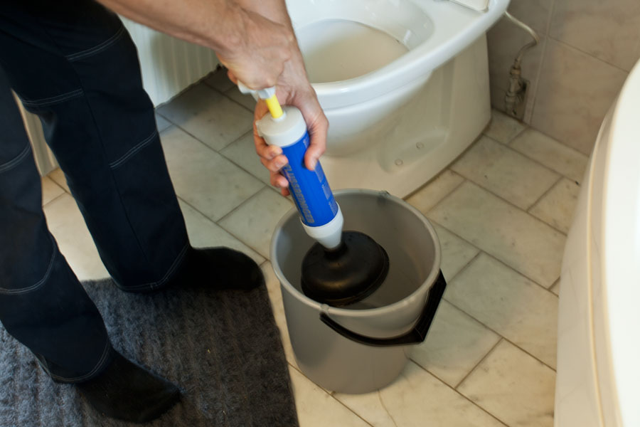 Använder avloppspump för att rensa bort stopp i toalett